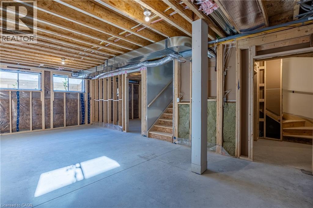 Unfinished basement featuring exposed wood joists, concrete flooring, and framed walls with insulation - 107 Amber Street, Waterford, ON - Indoor Photo Showing Basement