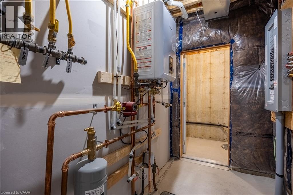 Utility room featuring an on-demand water heater, copper piping, PEX plumbing, and a circuit breaker panel - 107 Amber Street, Waterford, ON - Indoor Photo Showing Basement