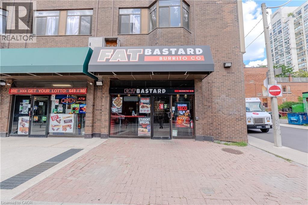 Brick facade commercial building with ground-level retail spaces and upper-level windows - 96 Gerrard St E, Toronto, ON