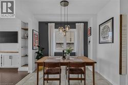 Dining area featuring a contemporary pendant light fixture, a window with drapery, and tile flooring -