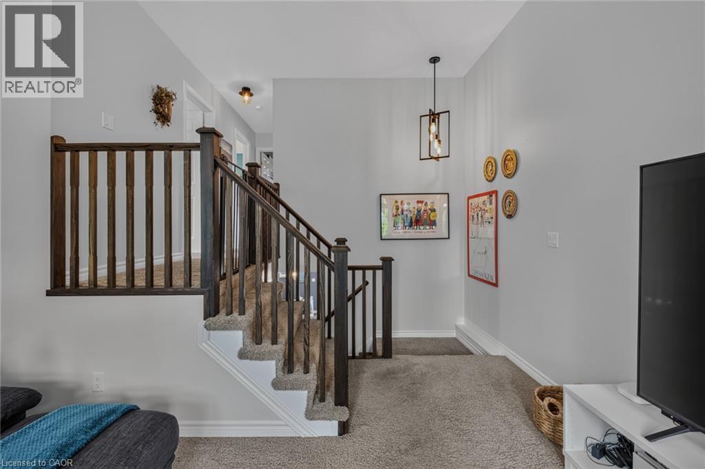 Carpeted staircase with dark wood balusters and handrail - 174 Woodway Trail, Simcoe, ON - Indoor Photo Showing Other Room