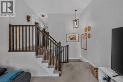 Carpeted staircase with dark wood balusters and handrail -
