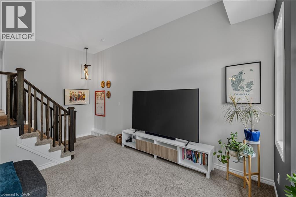 Living area with a high vaulted ceiling, carpeted flooring, and a window providing natural light - 174 Woodway Trail, Simcoe, ON - Indoor Photo Showing Other Room