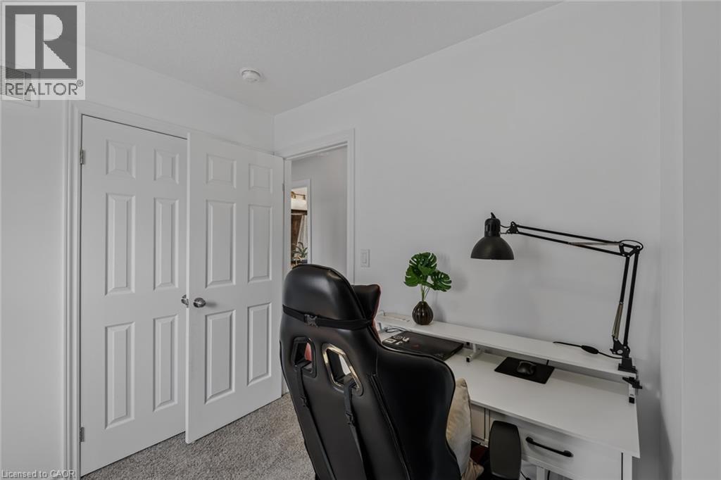 Bright interior space featuring white walls, textured carpeting, and white panel doors with brushed nickel hardware - 174 Woodway Trail, Simcoe, ON - Indoor