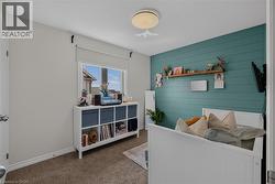 Room featuring a shiplap accent wall, neutral carpeting, and a window with a roller shade -