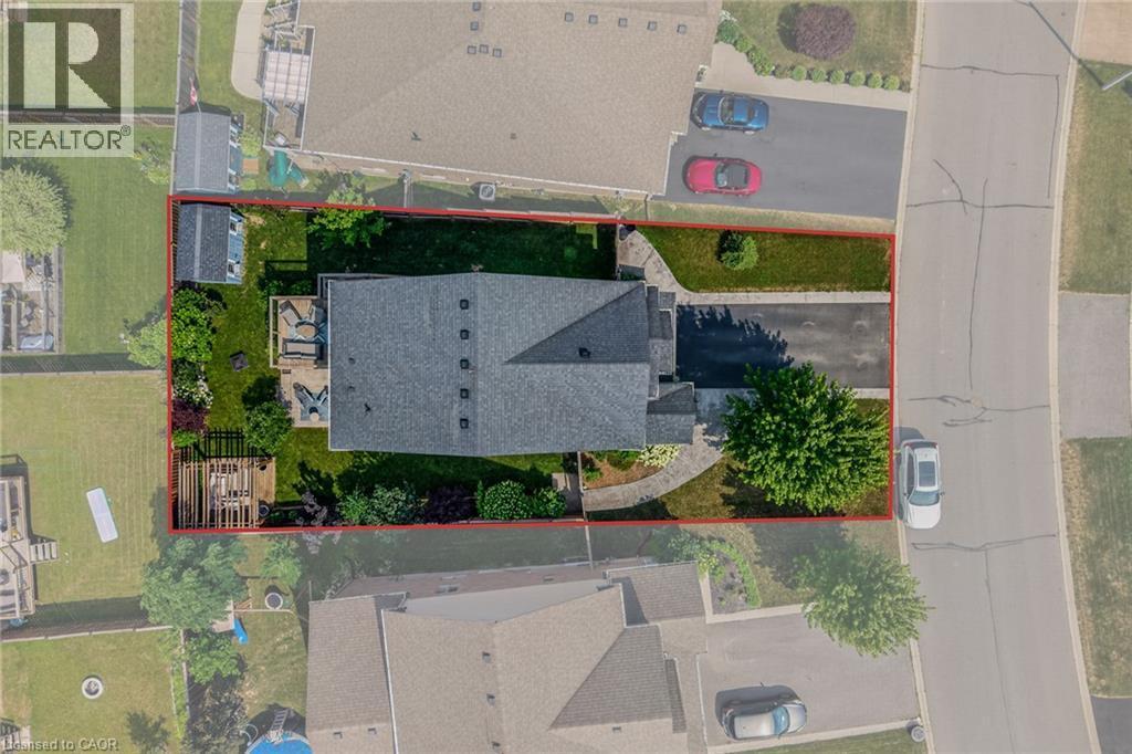 Aerial perspective showcasing a property with a dark shingle roof and a paved driveway - 174 Woodway Trail, Simcoe, ON -