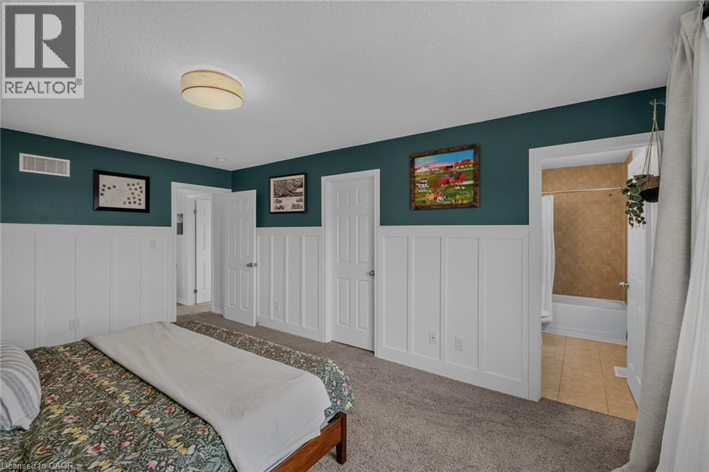 Bedroom featuring carpet flooring and board and batten wall detailing - 174 Woodway Trail, Simcoe, ON - Indoor Photo Showing Bedroom
