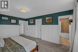 Bedroom featuring carpet flooring and board and batten wall detailing -