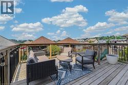 Spacious wooden deck featuring a perimeter railing with black spindles and string lighting -