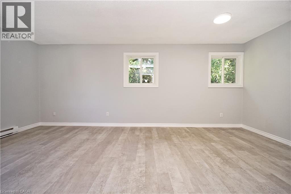 Spacious room featuring wood-finish flooring, light gray wall paint, and white baseboards - 119 Cedar Street S Unit# 14, Kitchener, ON - Indoor Photo Showing Other Room