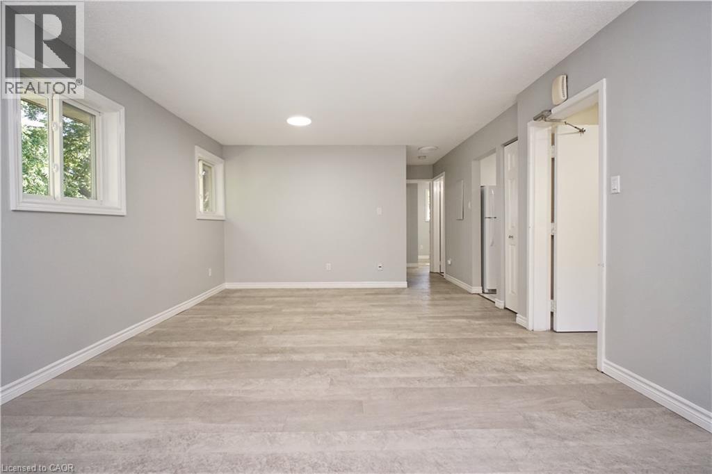 Spacious room featuring light wood-finish flooring, two windows with white trim, and a ceiling-mounted light fixture - 119 Cedar Street S Unit# 14, Kitchener, ON - Indoor Photo Showing Other Room