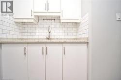 White cabinetry with brushed nickel hardware, light-toned countertop, and classic subway tile backsplash -