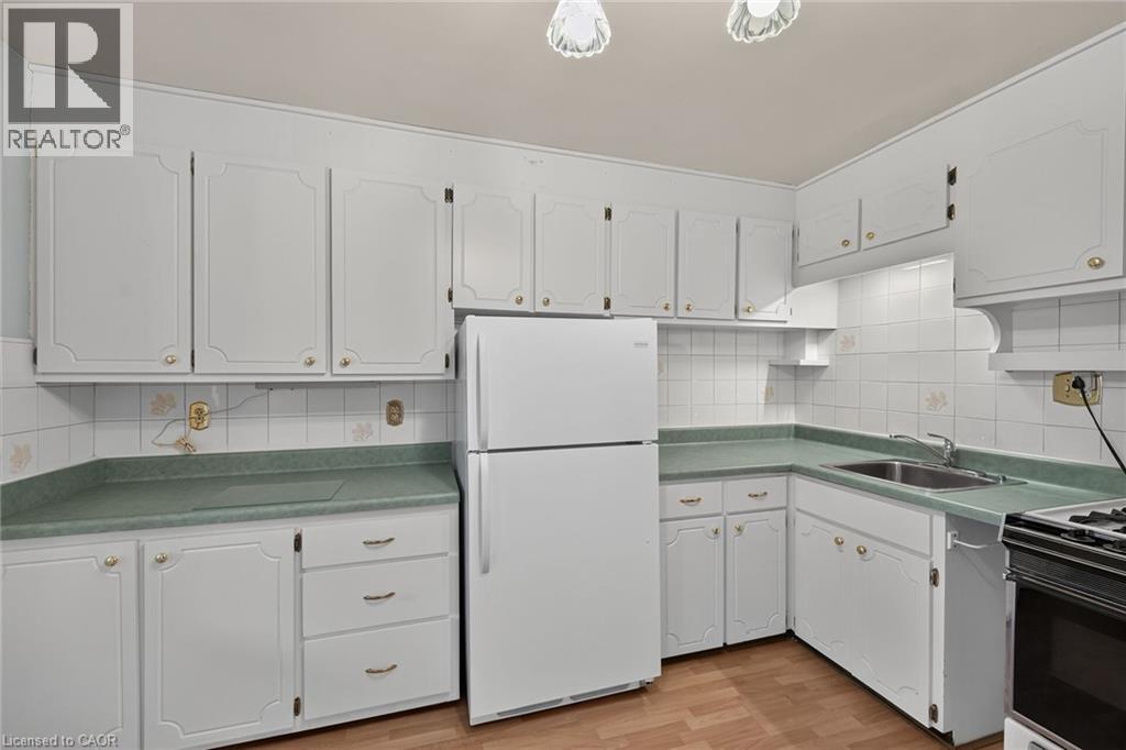 Kitchen featuring white cabinetry with decorative paneling and brass hardware - 155 Newlands Avenue, Hamilton, ON - Indoor Photo Showing Kitchen