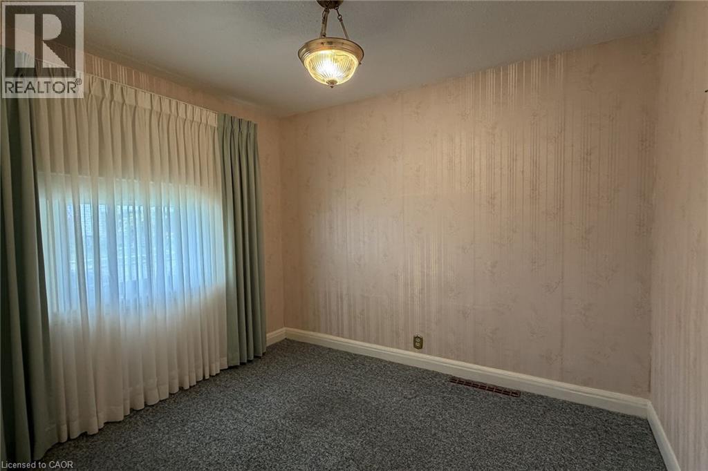 Room featuring textured wallpaper, wall-to-wall carpeting, and a window with both sheer and solid drapes - 155 Newlands Avenue, Hamilton, ON - Indoor Photo Showing Other Room