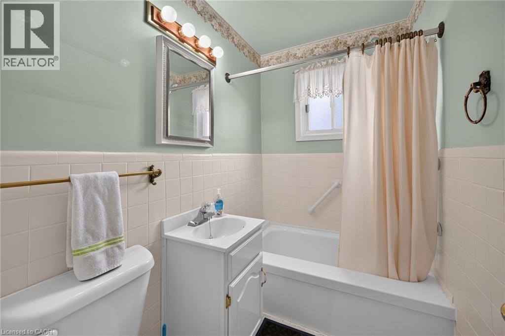 Bathroom featuring a white vanity with integrated sink, chrome faucet, and mirrored medicine cabinet - 155 Newlands Avenue, Hamilton, ON - Indoor Photo Showing Bathroom