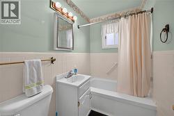 Bathroom featuring a white vanity with integrated sink, chrome faucet, and mirrored medicine cabinet -