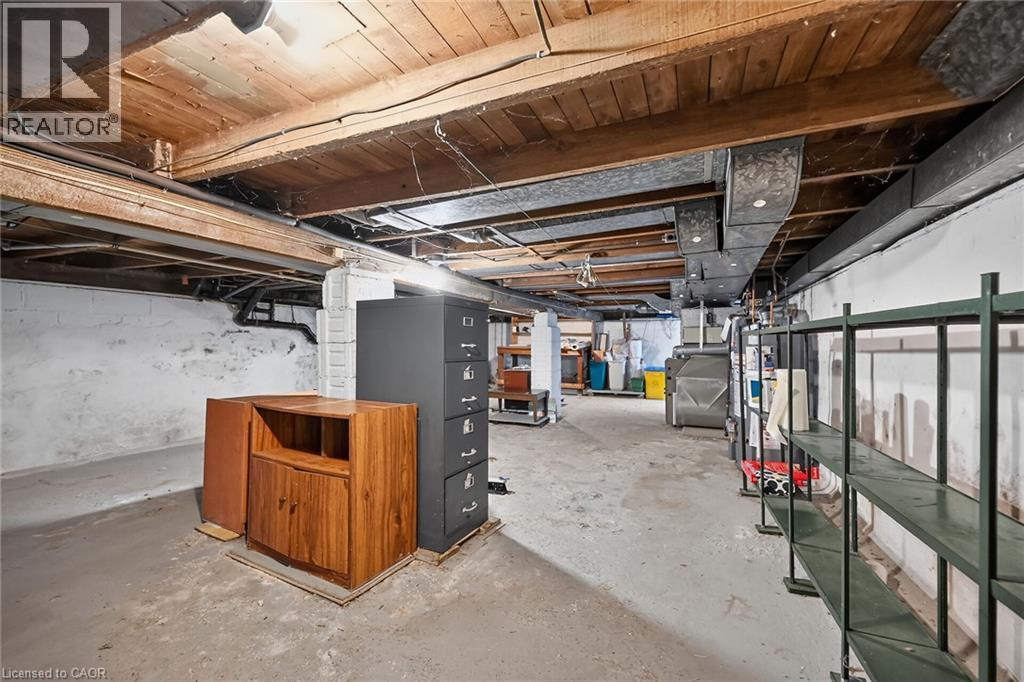 Unfinished basement with concrete flooring, exposed wood ceiling beams, painted cinder block walls, and visible ductwork - 155 Newlands Avenue, Hamilton, ON - Indoor Photo Showing Basement