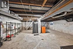 Unfinished basement featuring exposed joists and concrete flooring -