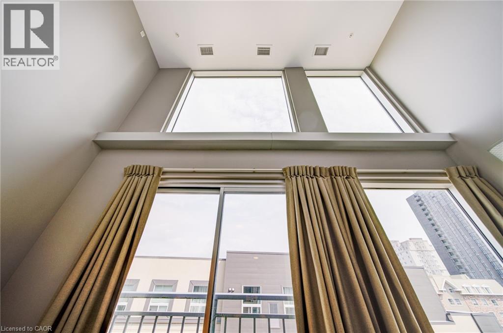 Vaulted ceiling with multiple upper windows and a lower sliding glass door - 321 Spruce Street Unit# 710, Waterloo, ON - Indoor Photo Showing Other Room