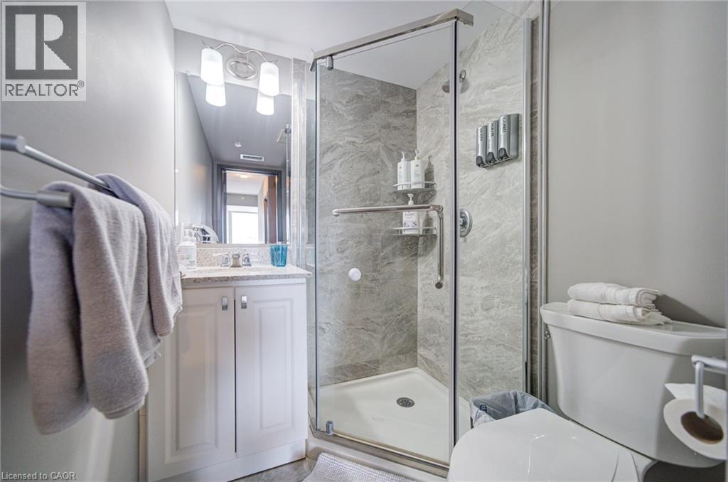 Walk-in shower with clear glass enclosure and stone-look wall tile - 321 Spruce Street Unit# 710, Waterloo, ON - Indoor Photo Showing Bathroom