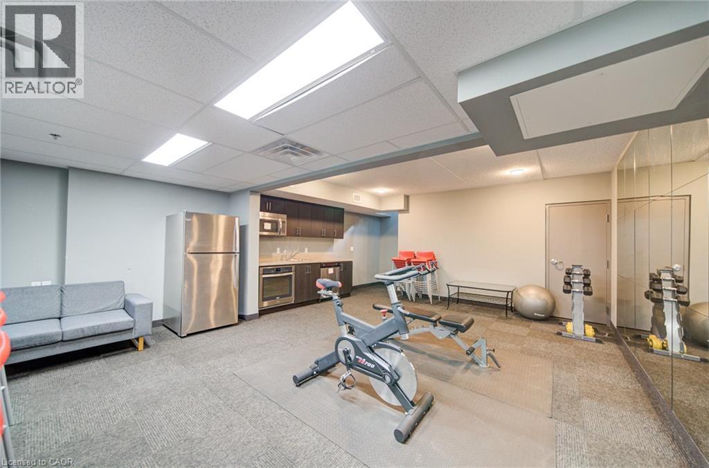Fitness area featuring mirror wall, recessed lighting, and a kitchenette with stainless steel appliances - 321 Spruce Street Unit# 710, Waterloo, ON - Indoor