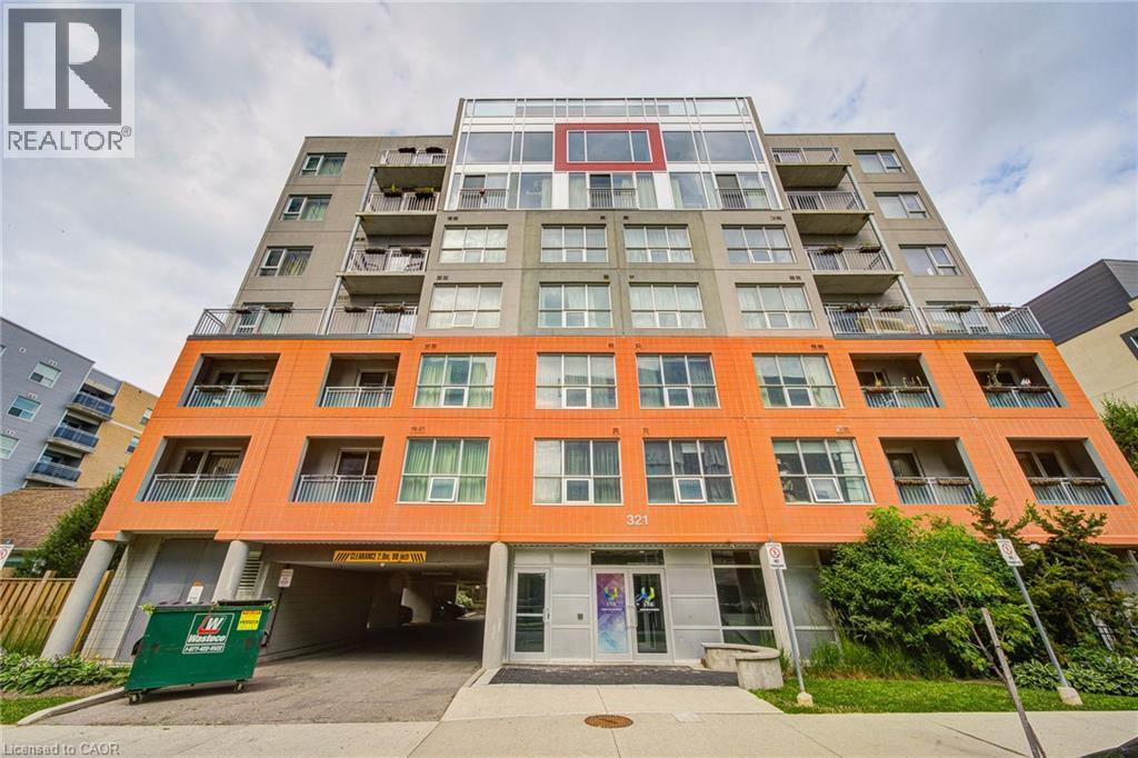Contemporary multi-story building featuring a distinctive orange facade on the lower levels, contrasting with gray and white upper sections - 321 Spruce Street Unit# 710, Waterloo, ON - Outdoor With Facade