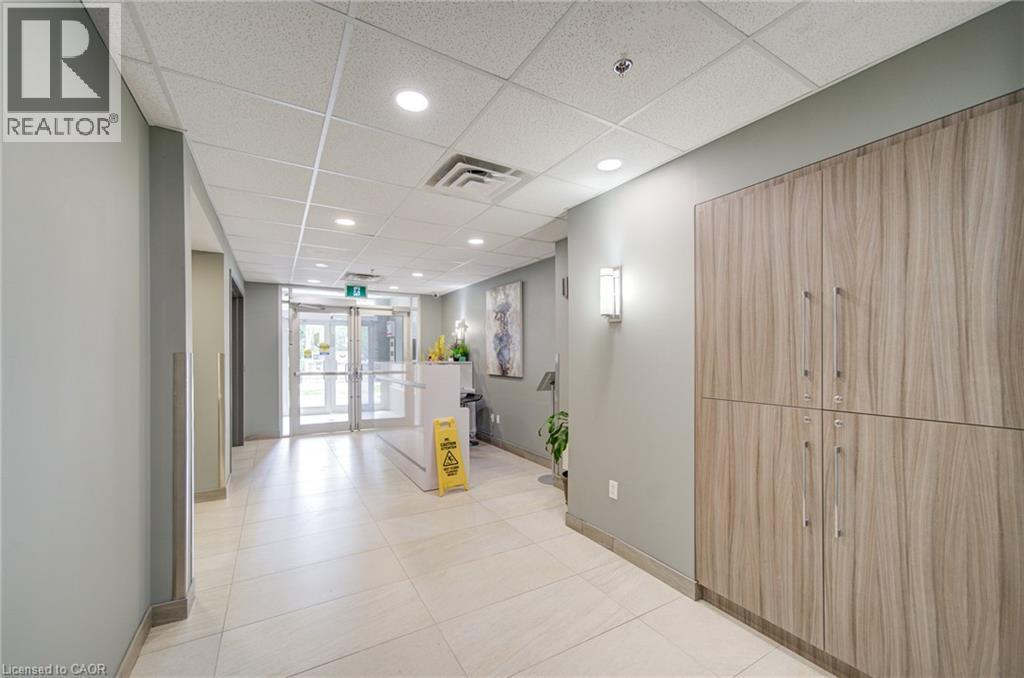 Modern entryway featuring double glass doors, recessed lighting, grid acoustic ceiling, and wood-finish cabinetry - 321 Spruce Street Unit# 710, Waterloo, ON - Indoor Photo Showing Other Room