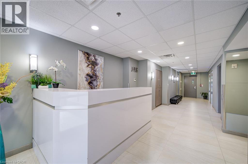 Bright reception area featuring a white, contemporary desk, recessed lighting, and light-toned floor tiling - 321 Spruce Street Unit# 710, Waterloo, ON - Indoor Photo Showing Other Room
