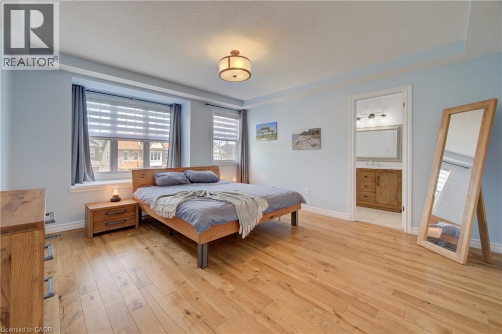 Spacious bedroom featuring light wood-finish flooring, light blue walls, and a recessed ceiling design - 729 Keats Way, Waterloo, ON - Indoor Photo Showing Bedroom