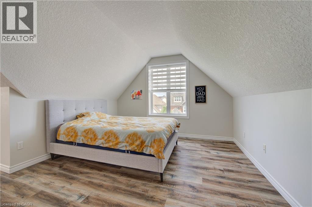 Room featuring wood-finish flooring, a window with horizontal blinds, and a sloped ceiling - 729 Keats Way, Waterloo, ON - Indoor Photo Showing Bedroom