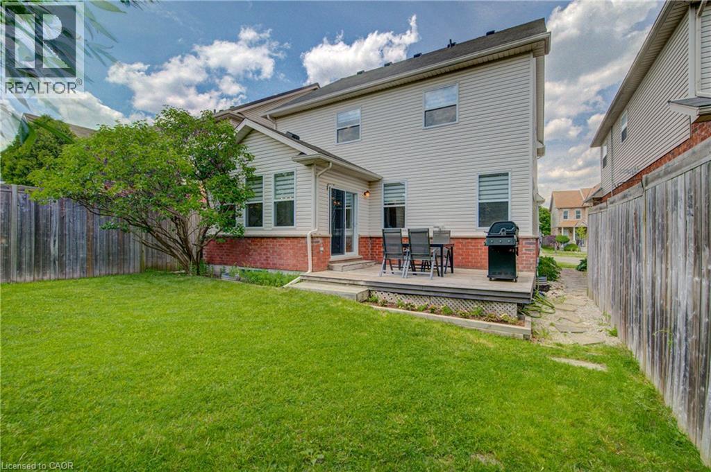 Expansive green lawn with a mature tree, bordered by a wooden privacy fence - 729 Keats Way, Waterloo, ON - Outdoor With Deck Patio Veranda
