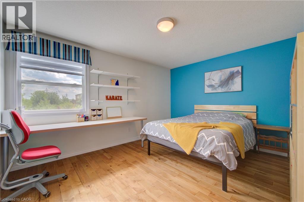 Bedroom featuring wood-finish flooring and a bright accent wall - 729 Keats Way, Waterloo, ON - Indoor Photo Showing Bedroom