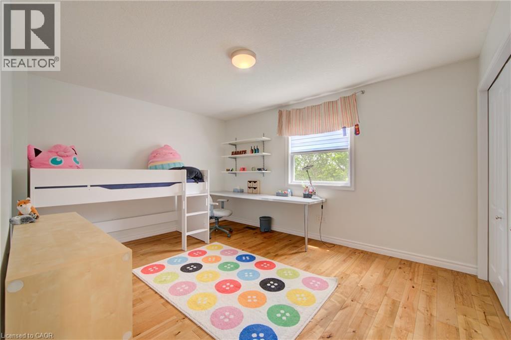 Bright room featuring wood-finish flooring, a window with horizontal blinds, and a built-in desk with shelving - 729 Keats Way, Waterloo, ON - Indoor Photo Showing Bedroom
