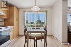 Dining area with wood-finish flooring and a sliding glass door opening to a deck overlooking a body of water -