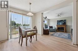 Waterfront dining area with a glass sliding door, pendant lighting, and wood-finish flooring -
