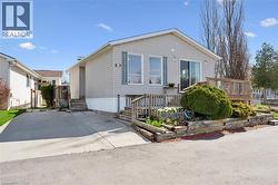 Siding exterior with a front deck featuring wooden railings and steps -