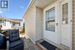Front entrance with a white storm door and main entry door, featuring a side window pane -