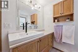 Bathroom featuring a white rectangular vessel sink, matte black faucet, and light wood-finish vanity with drawer storage -