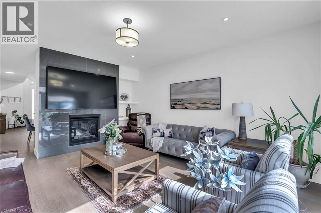 Spacious living area featuring light wood-finish flooring, a contemporary fireplace with a dark tile surround, and recessed lighting - 2195 Ironwood Road, London, ON - Indoor Photo Showing Living Room With Fireplace