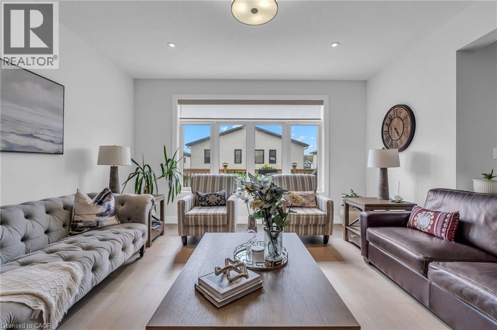 Spacious living area featuring light wood-finish flooring, a large window, recessed lighting, and a prominent ceiling fixture - 2195 Ironwood Road, London, ON - Indoor Photo Showing Living Room
