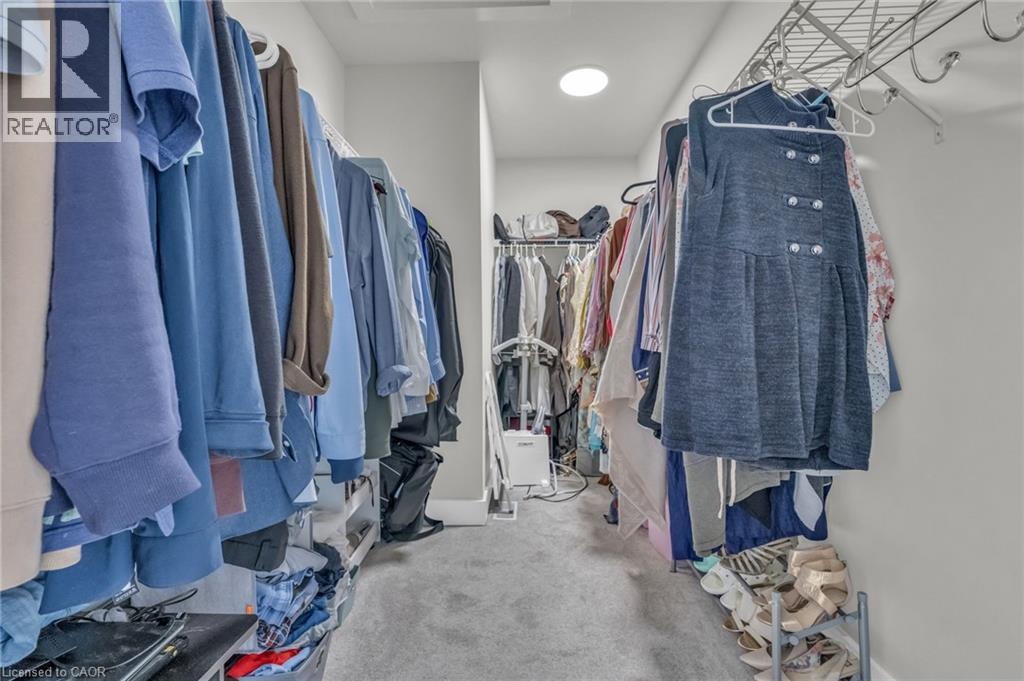 Walk-in closet with carpet flooring, recessed ceiling lighting, and multiple shelving and hanging storage systems - 2195 Ironwood Road, London, ON - Indoor With Storage