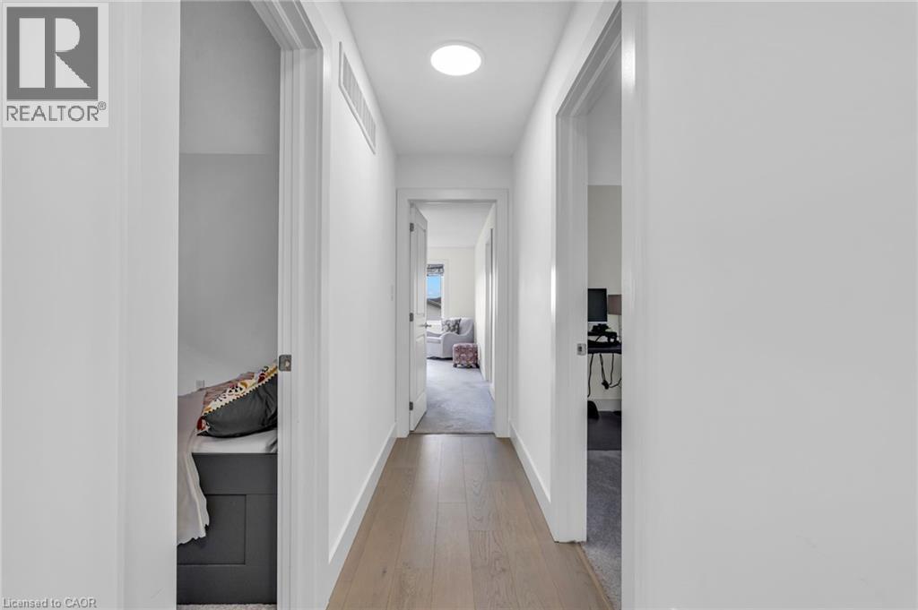 Modern hallway featuring wide-plank wood-finish flooring, white walls, and recessed lighting - 2195 Ironwood Road, London, ON - Indoor Photo Showing Other Room