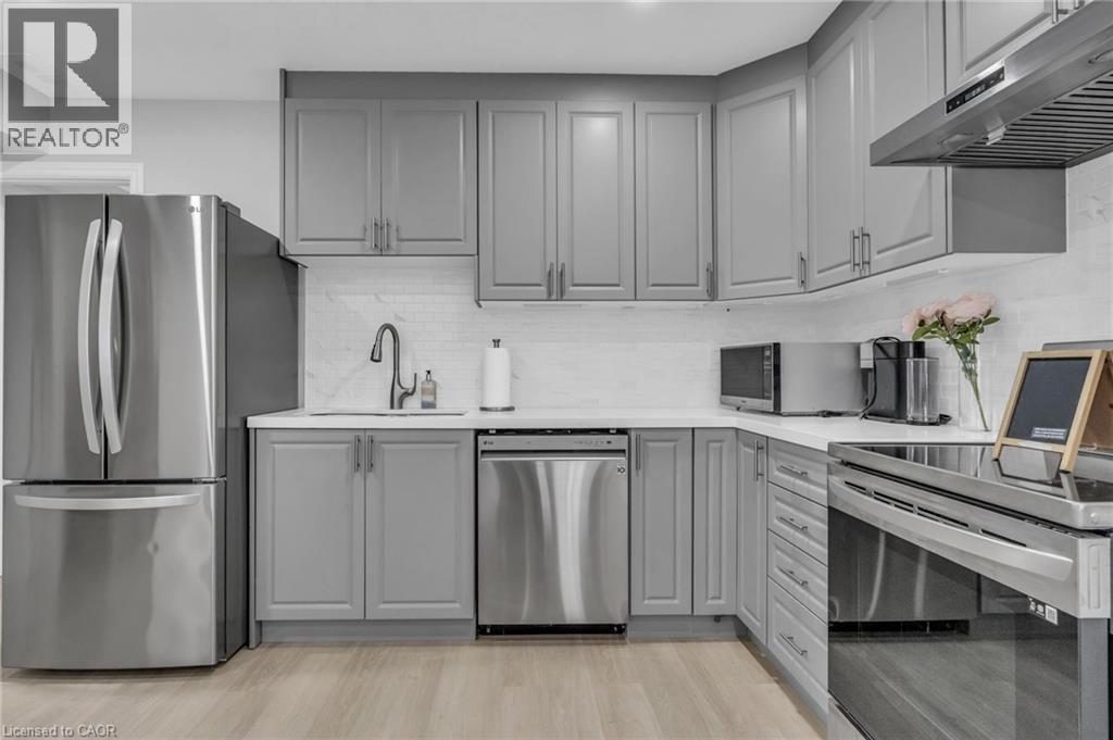Kitchen featuring light gray cabinetry, stainless steel appliances, white countertops, and a white subway tile backsplash - 2195 Ironwood Road, London, ON - Indoor Photo Showing Kitchen With Stainless Steel Kitchen