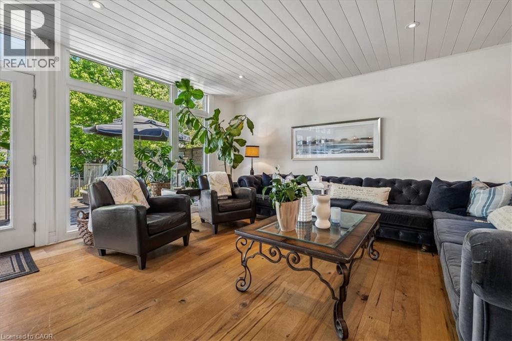 Living area featuring wide plank wood-finish flooring, a white tongue and groove ceiling, recessed lighting, and expansive windows - 573 Beach Boulevard, Hamilton, ON - Indoor Photo Showing Living Room