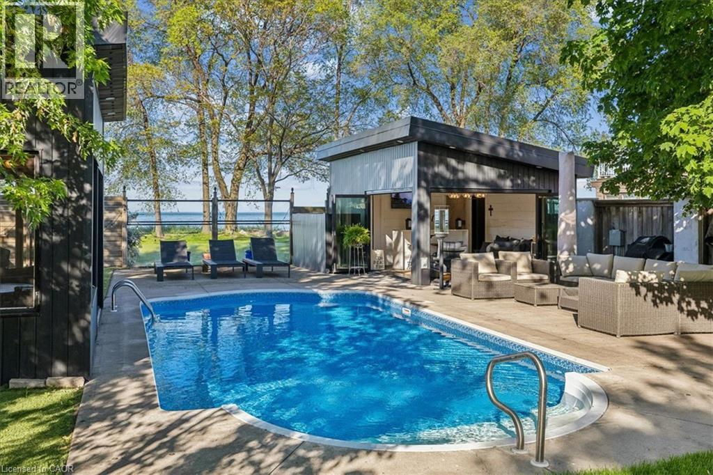 Rectangular swimming pool with integrated steps, surrounded by concrete decking - 573 Beach Boulevard, Hamilton, ON - Outdoor With In Ground Pool With Deck Patio Veranda
