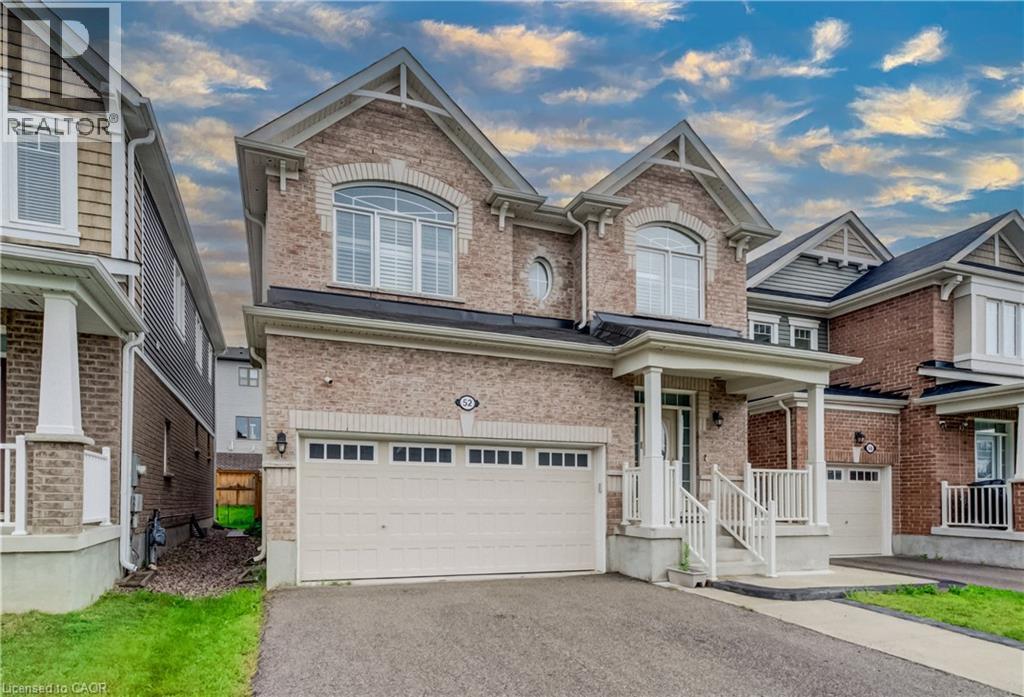 Two-story brick facade residence featuring a covered front porch with white columns, an attached two-car garage, and arched windows on the upper level - 52 Pointer Street, Cambridge, ON - Outdoor With Facade