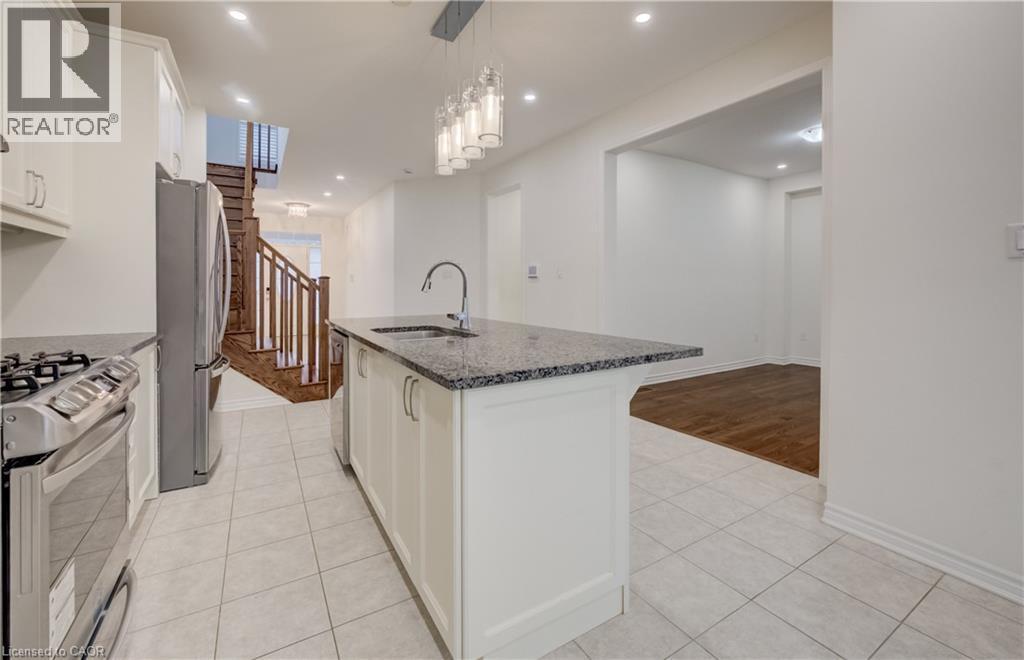 Kitchen island featuring a sink with a gooseneck faucet and a speckled countertop - 52 Pointer Street, Cambridge, ON - Indoor Photo Showing Kitchen With Upgraded Kitchen