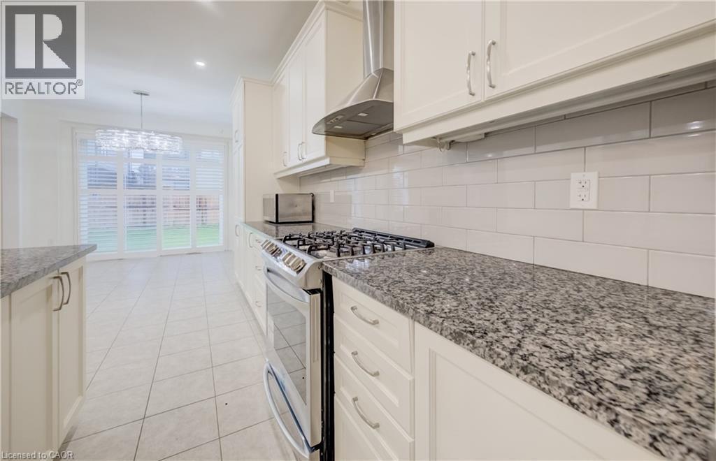 Kitchen featuring cream-colored cabinetry, granite countertops, and a subway tile backsplash - 52 Pointer Street, Cambridge, ON - Indoor Photo Showing Kitchen With Upgraded Kitchen