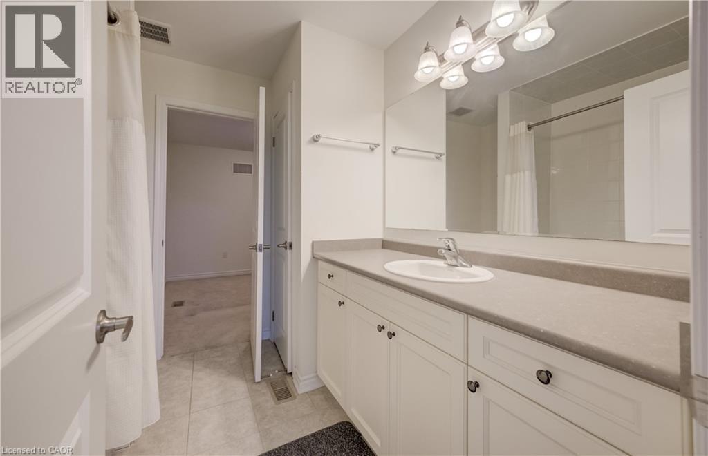 Bathroom vanity featuring an integrated sink, polished chrome faucet, and expansive mirror - 52 Pointer Street, Cambridge, ON - Indoor Photo Showing Bathroom