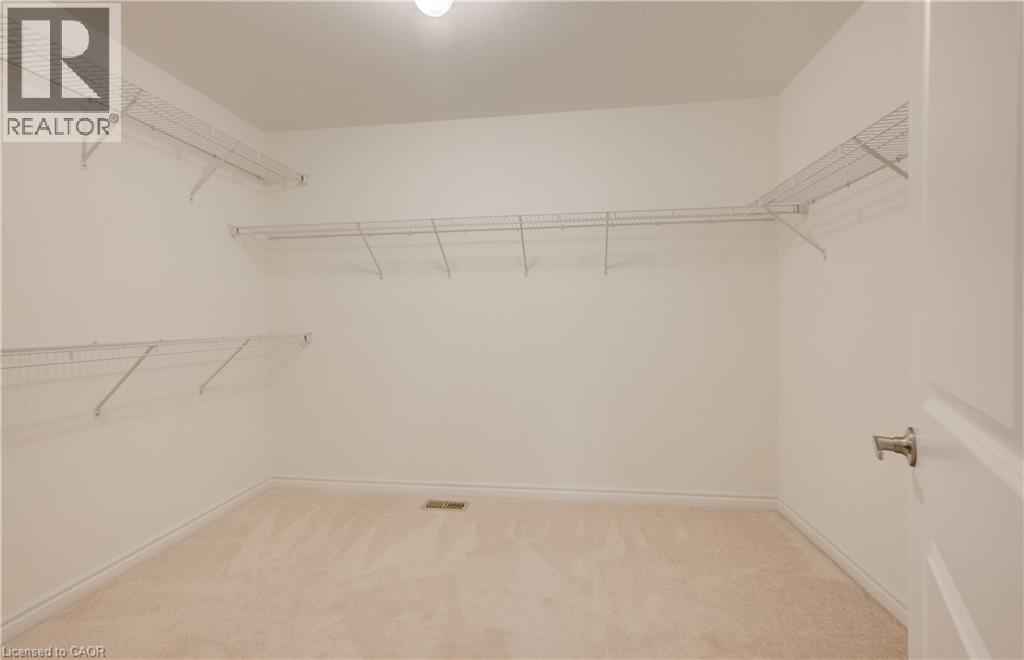 Spacious walk-in closet featuring light-colored carpeting, white walls, and built-in wire shelving - 52 Pointer Street, Cambridge, ON - Indoor With Storage